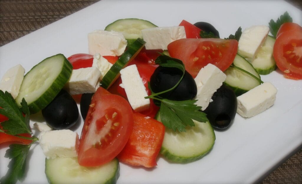 A plate with tomatoes, cucumbers, and feta cheese.