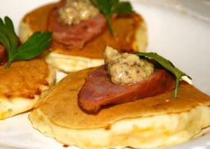 Pancakes with ham and cheese on a plate.