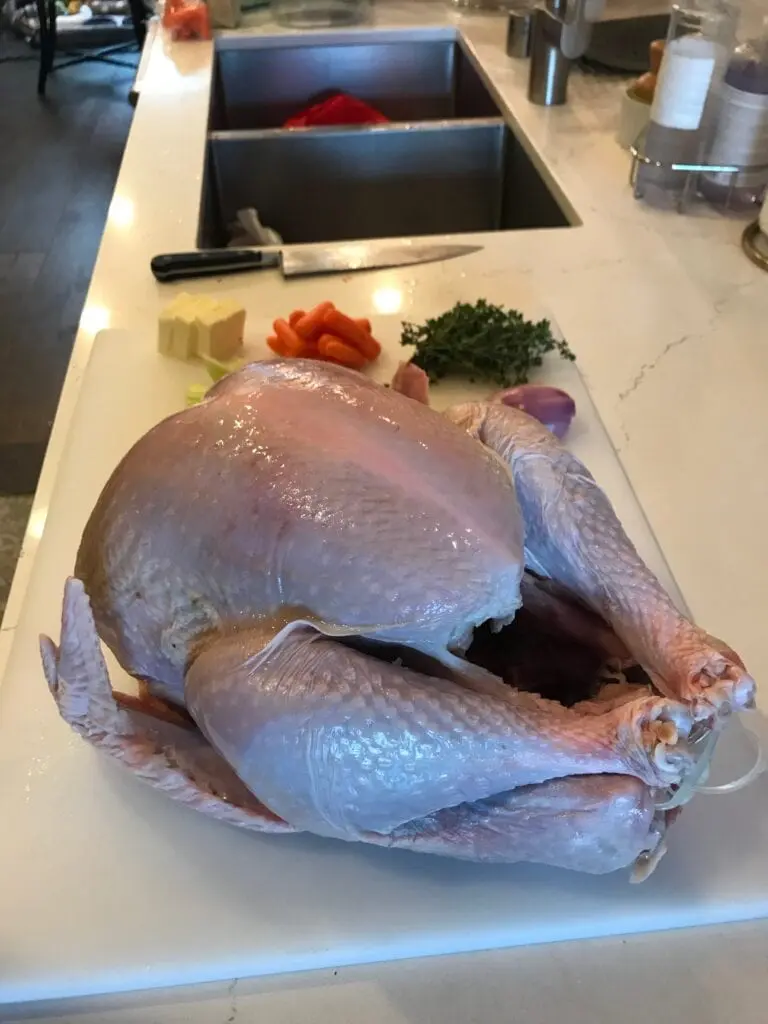 Get ready for Thanksgiving with these DIY turkey tips! A turkey is sitting on a cutting board in a kitchen.