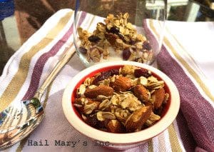 A bowl of cranberry almond granola and a spoon on the table, perfect for breakfast.