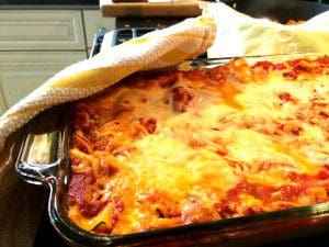 A traditional beef and cheese lasagna in a baking dish on the stove.