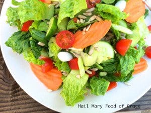 A simple salad with tomatoes, cucumbers, and carrots on a white plate - perfect for a quick and healthy meal.