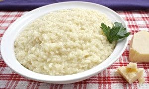 A bowl of three-cheese risotto topped with parsley.