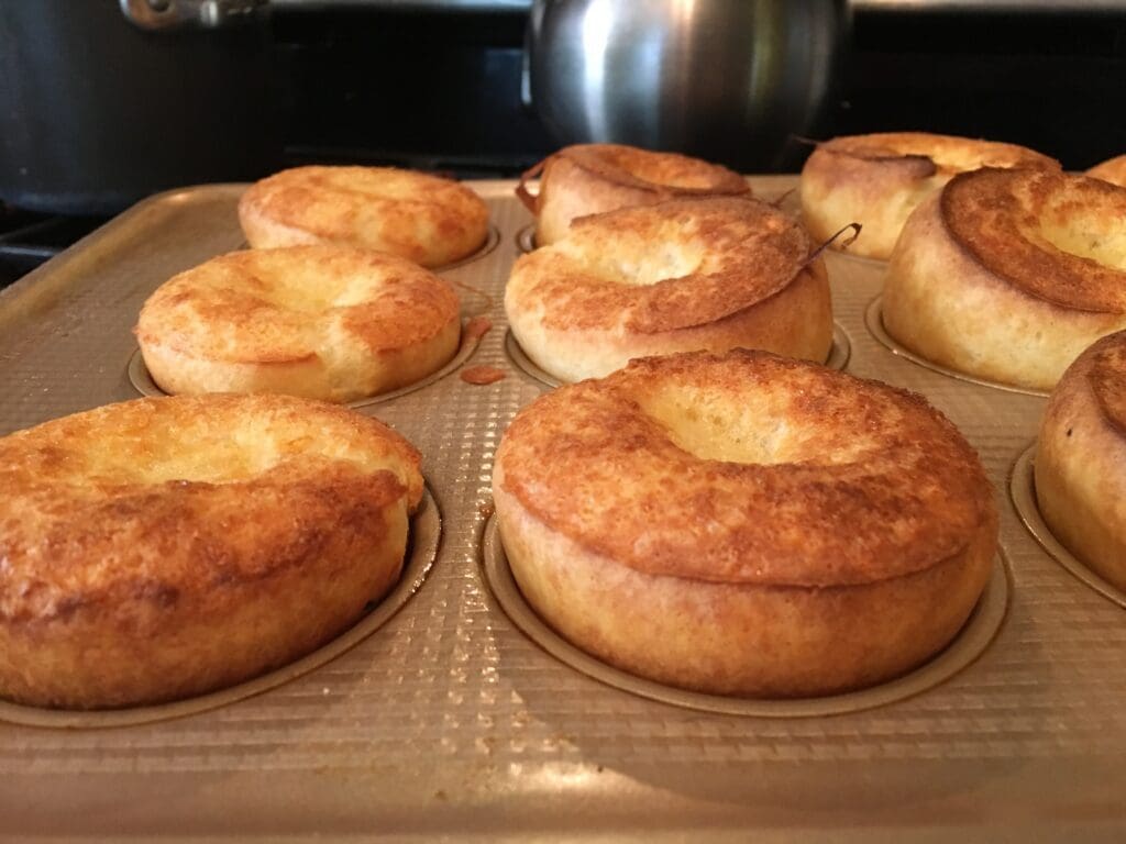 A tray of muffins sitting on top of a stove, perfect for your next popover recipe.