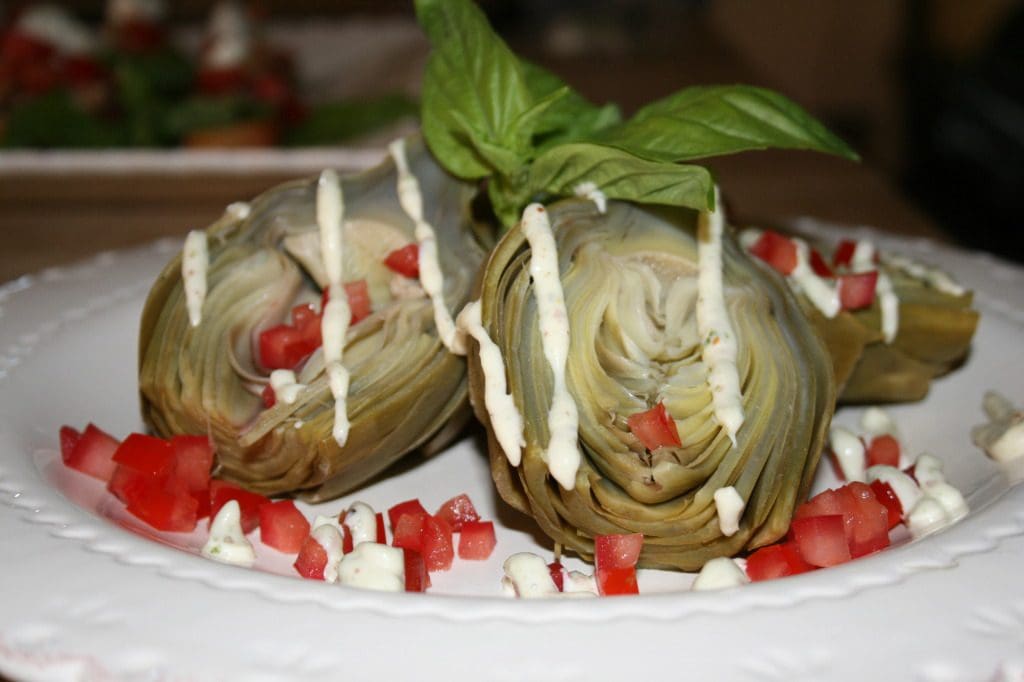Artichokes with tomatoes and sauce on a plate.
