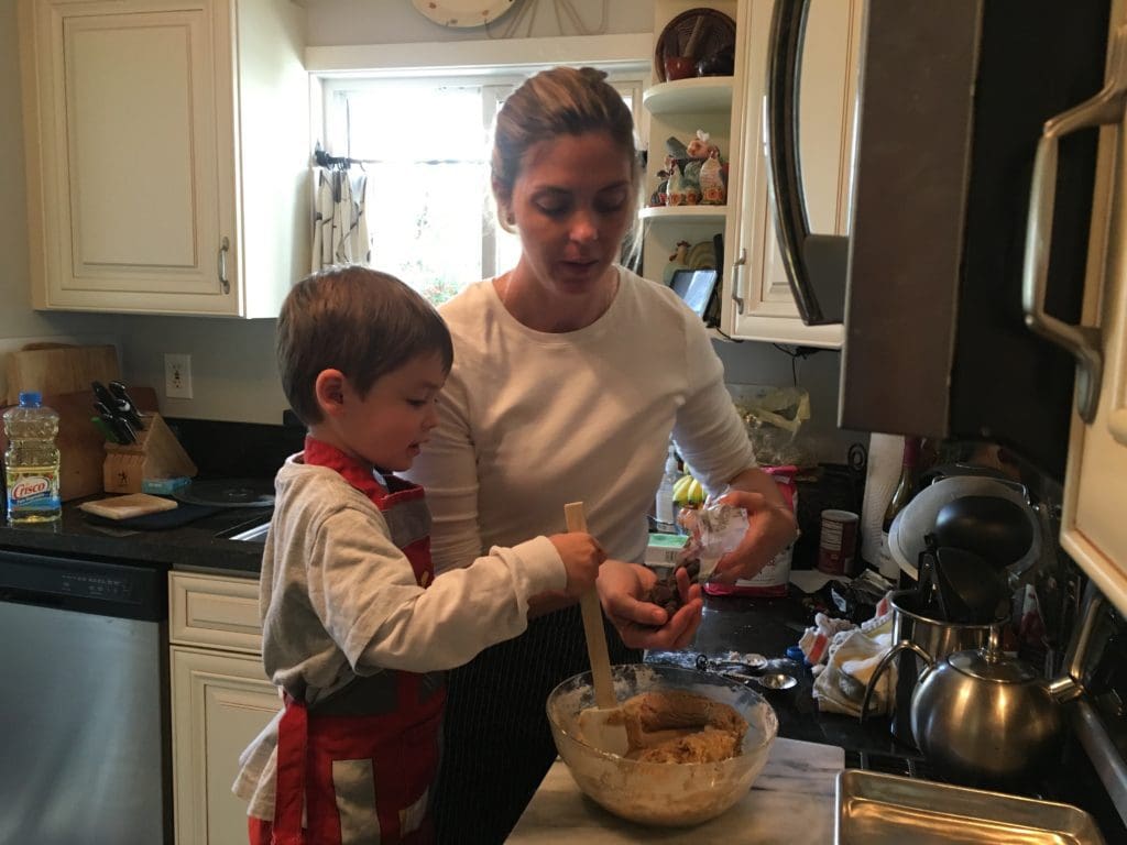 a woman and a child mixing a batter