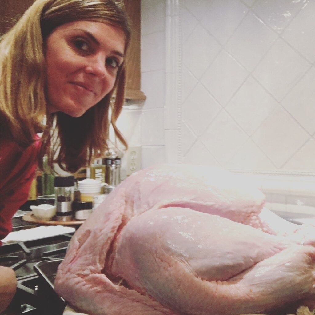 a woman taking a photo with a whole turkey meat