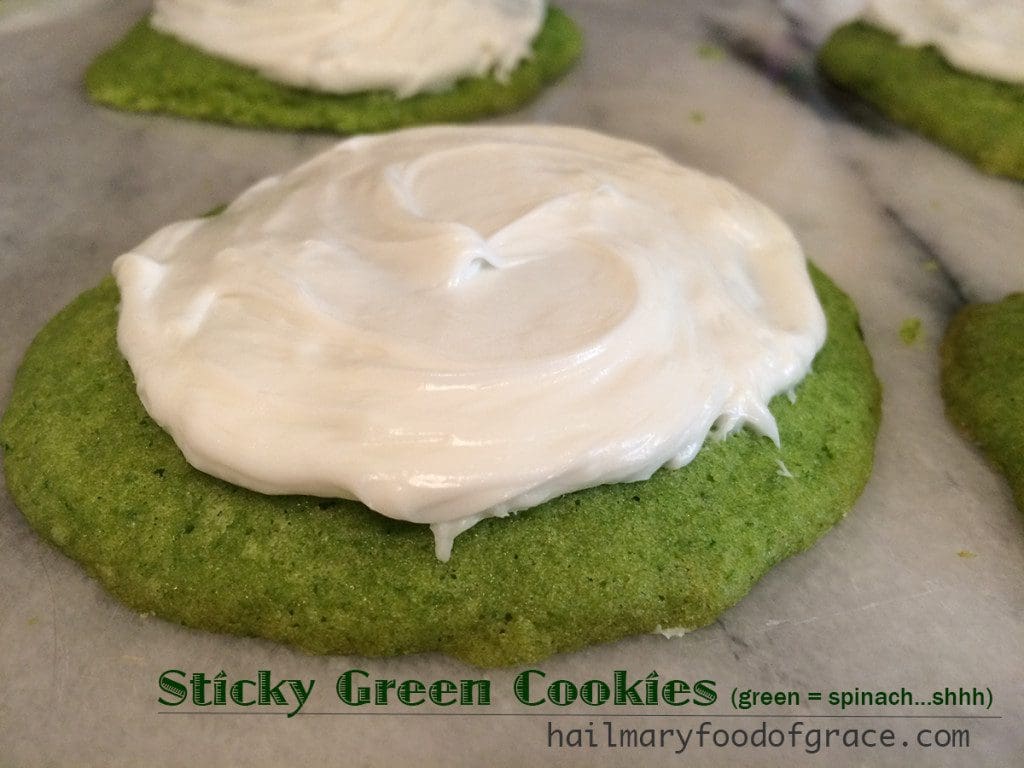 A green cookies with white frosting.