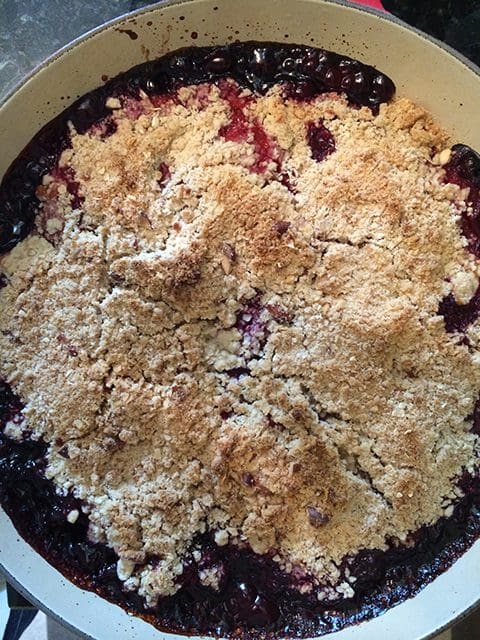 Blackberry crumble in a pan on a stove.
