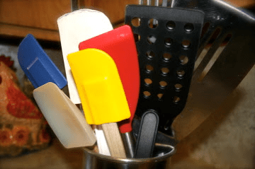 Kitchen utensils in a metal cup.