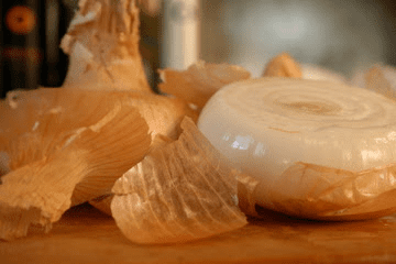 Onion and garlic on a cutting board.