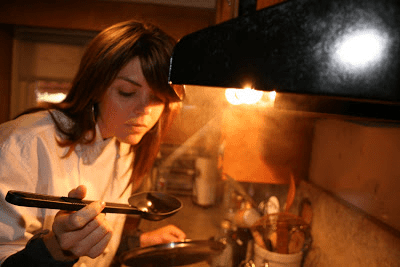 A woman is cooking in a kitchen.