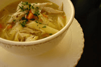 Chicken noodle soup in a white bowl.