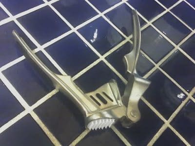 A pair of scissors on a tiled floor.