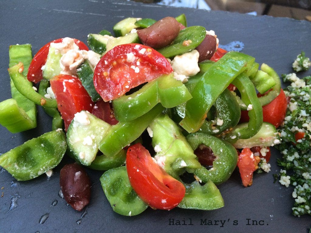 A plate with tomatoes, peppers and feta cheese.
