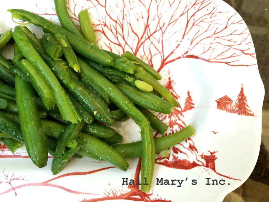 Green beans on a plate with a red and white pattern.