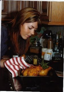 A woman preparing a turkey in the kitchen.
