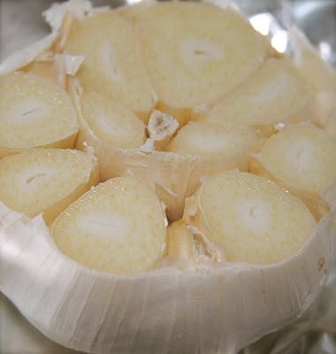 A piece of garlic is sitting on a piece of foil.