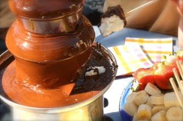 A chocolate fountain with strawberries and bananas.