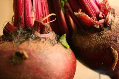 Two red beets on a brown background.