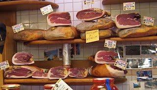 A display of meats and cheeses in a shop.