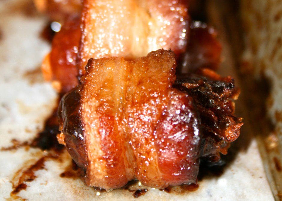 Bacon wrapped in bacon on a baking sheet.