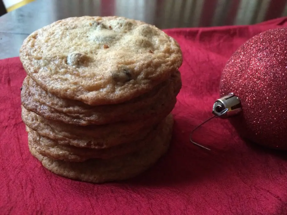 A stack of cookies next to a christmas ornament.