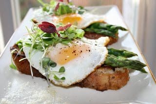 A plate with a fried egg and asparagus on it.
