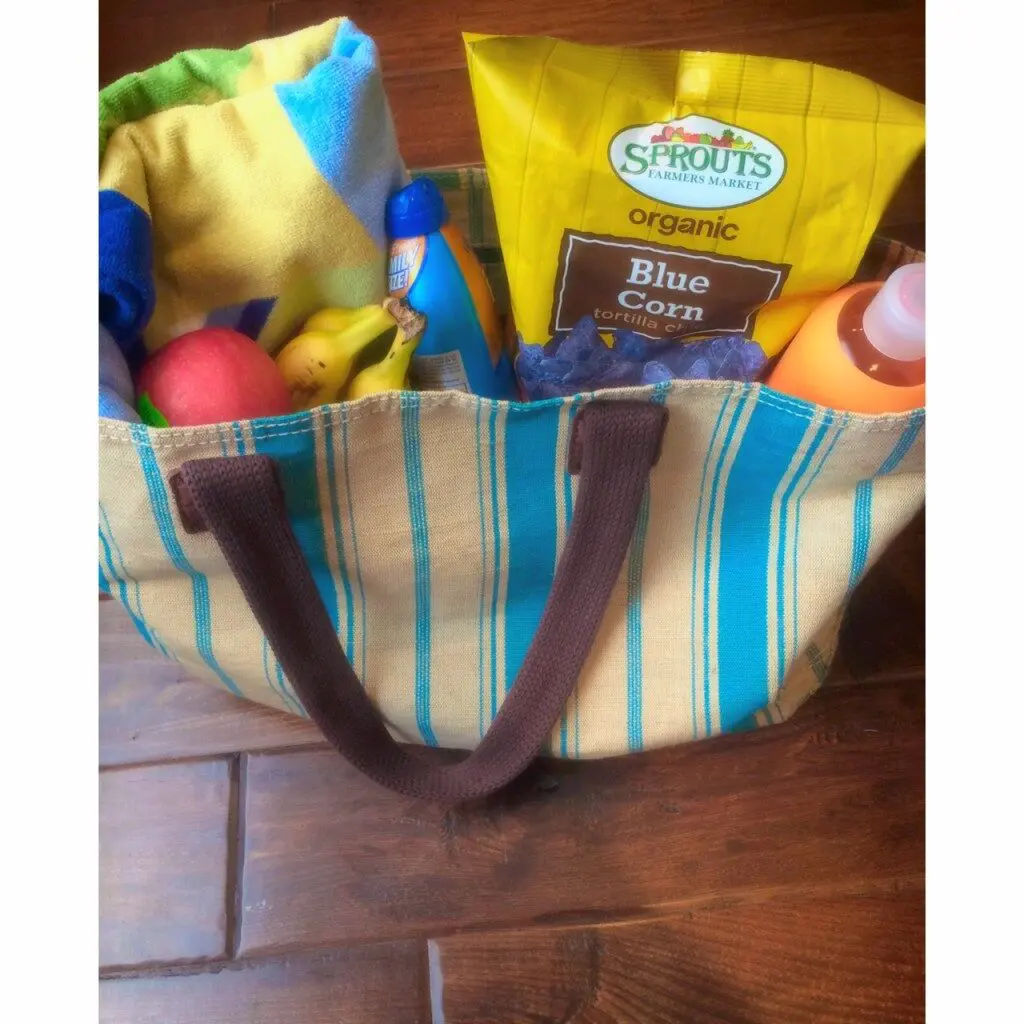 A tote bag filled with items for the beach.
