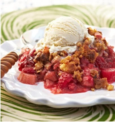 Strawberry crumble with ice cream on a plate.