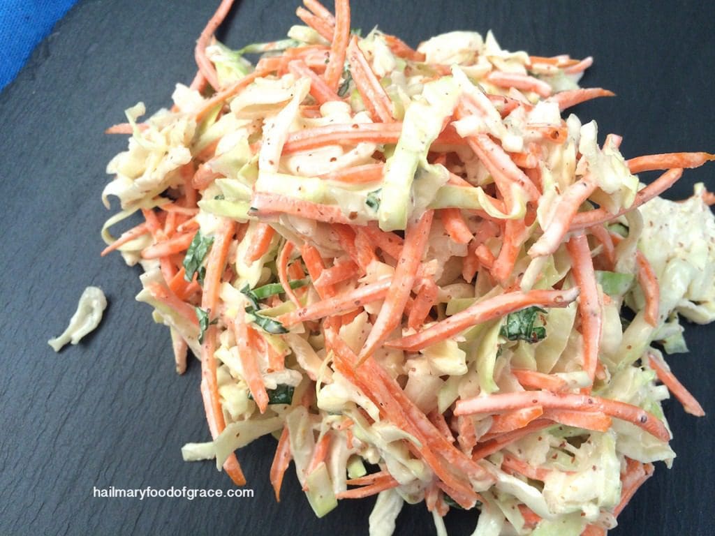 A pile of carrot slaw on a black plate.