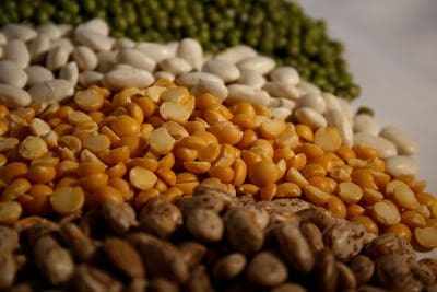 A pile of beans and peas on a white surface.