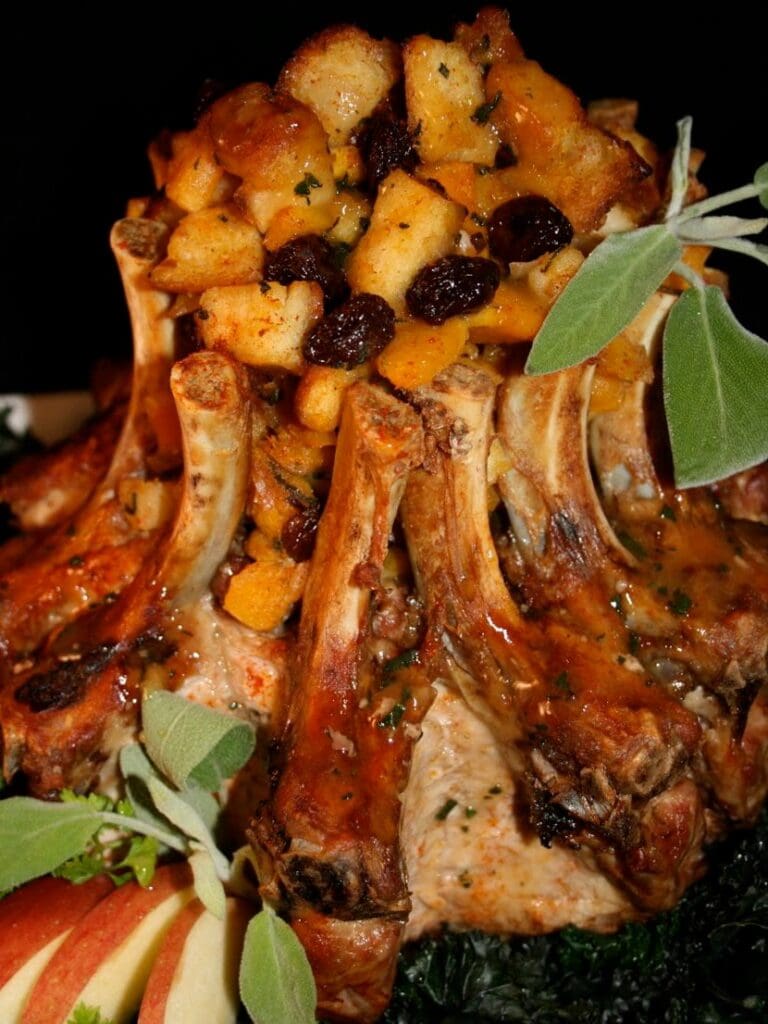 A pork roast with apples and cranberries on top.