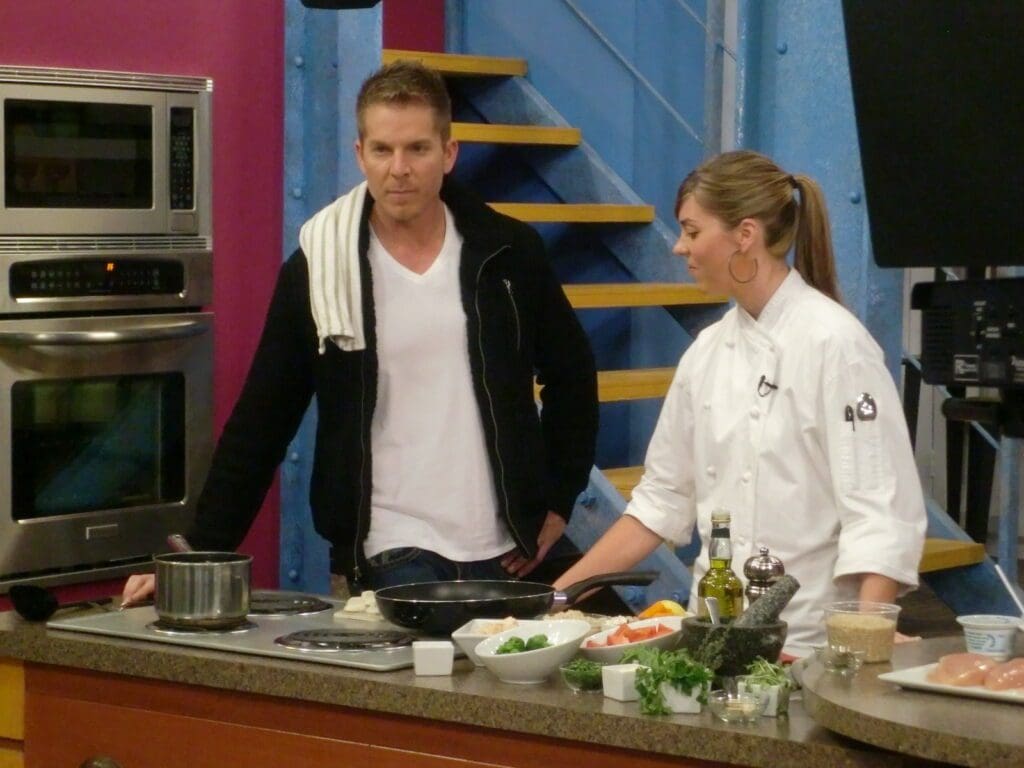 A man and woman standing in front of a kitchen.