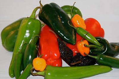 A pile of peppers on a white surface.