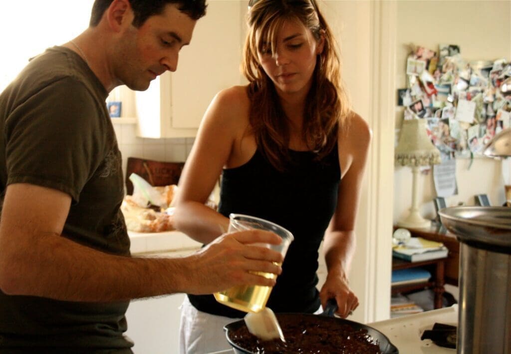 a man and woman cooking in the kitchen