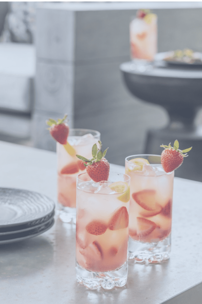 Three glasses of strawberry lemonade on a table.