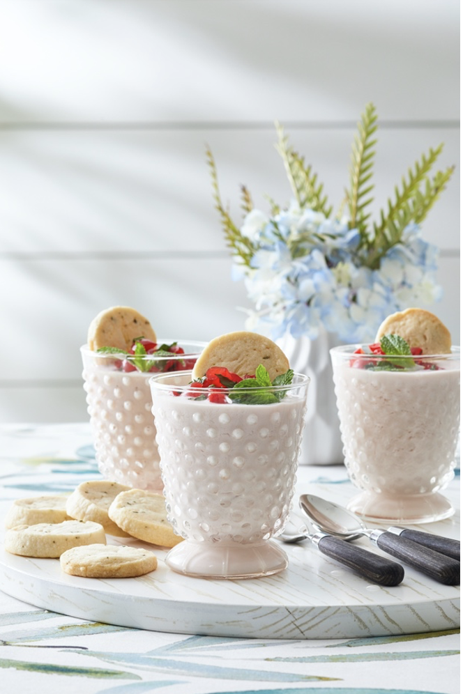 Three white cups with cookies on a plate.