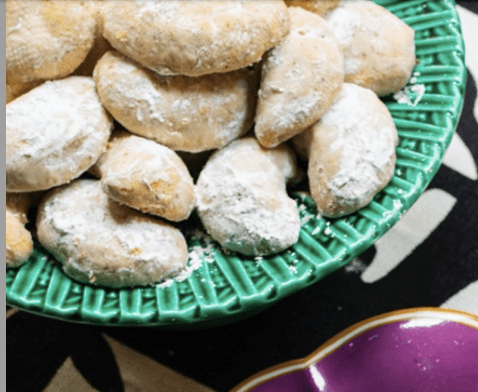 A bowl of cookies with powdered sugar in it.