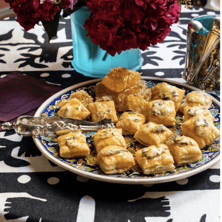 A plate of pastries on a table with flowers.