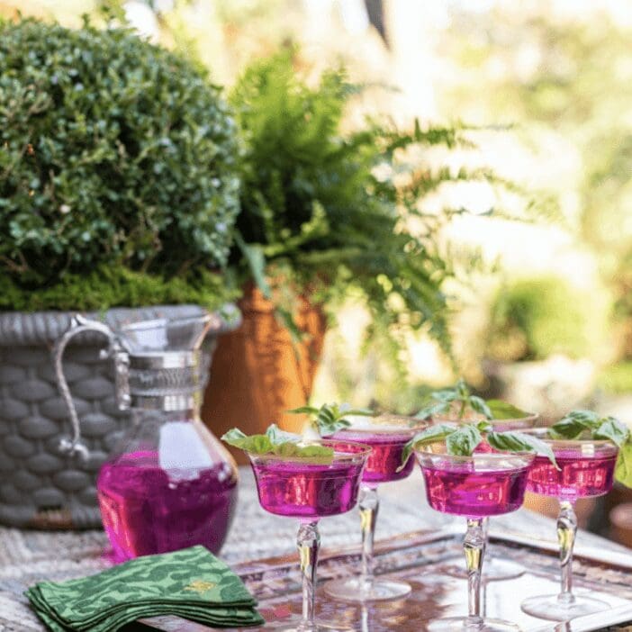 A tray of pink wine glasses on a table.