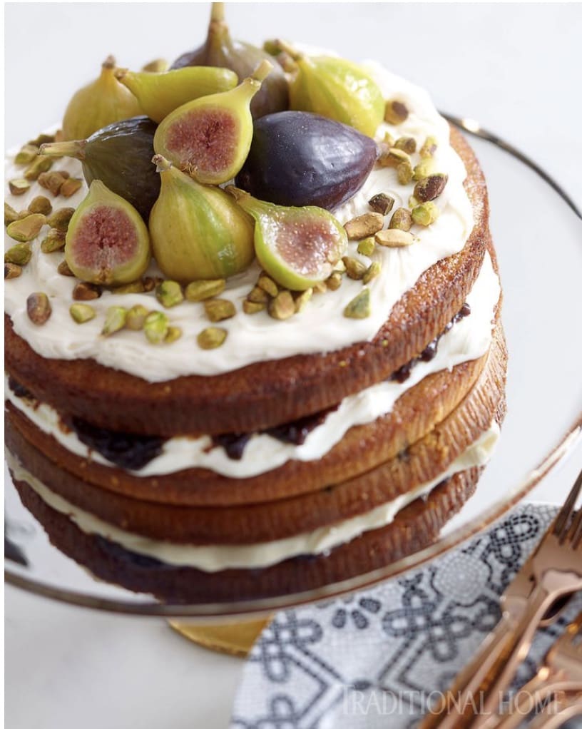 A cake with figs and cream on top.