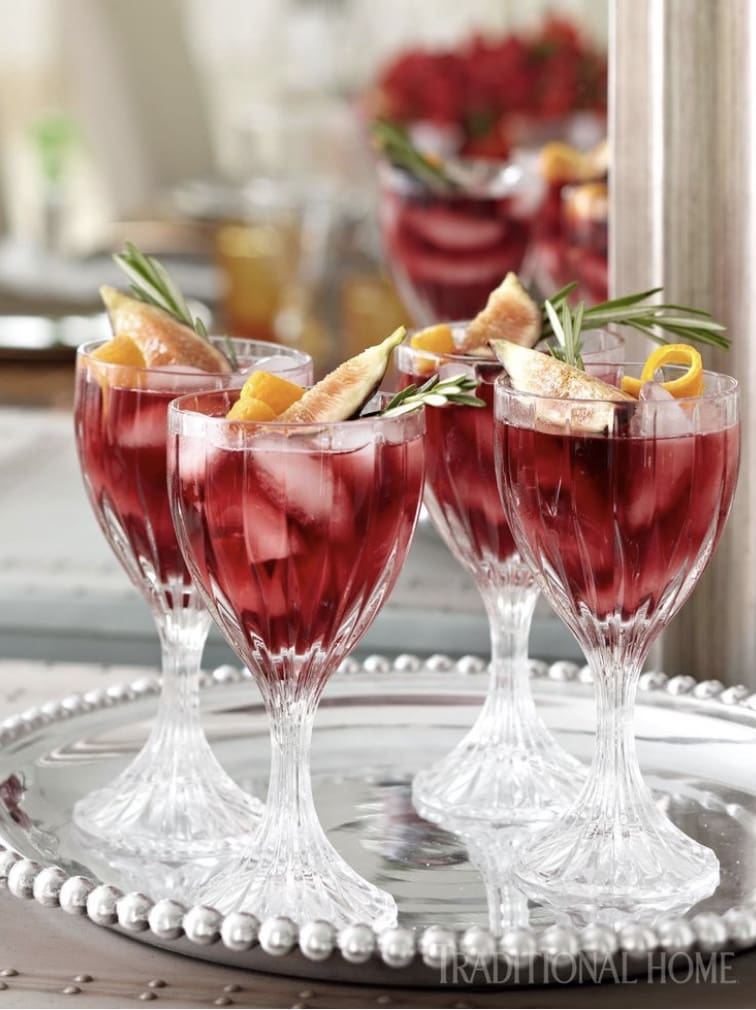 A glass of red sangria on a silver tray.