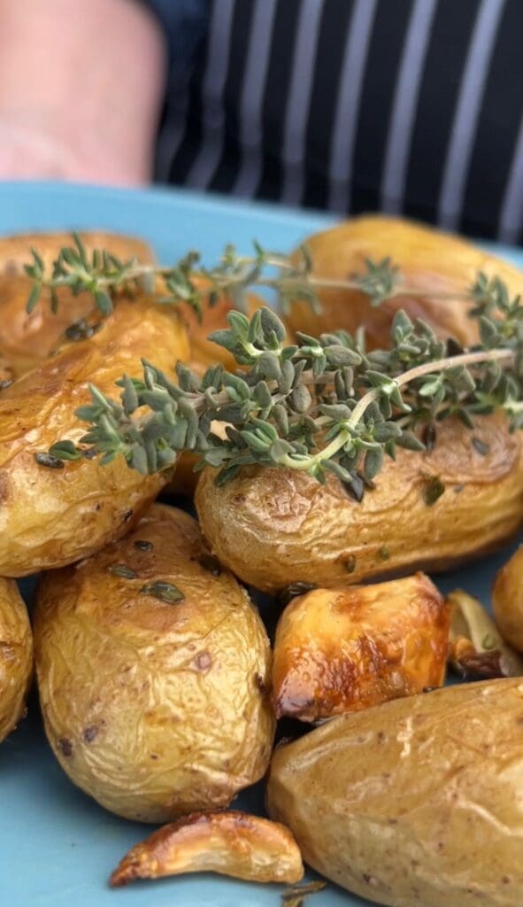 Golden roasted potatoes garnished with fresh herbs.