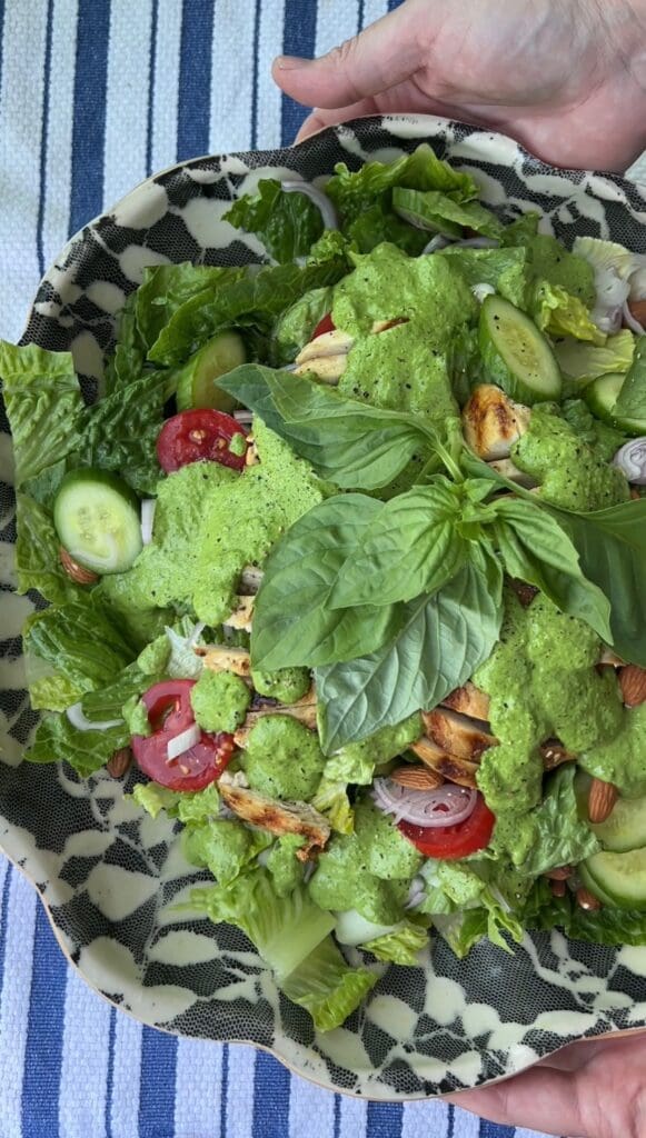 Fresh green salad with lettuce, cucumber, tomatoes, and herbs.