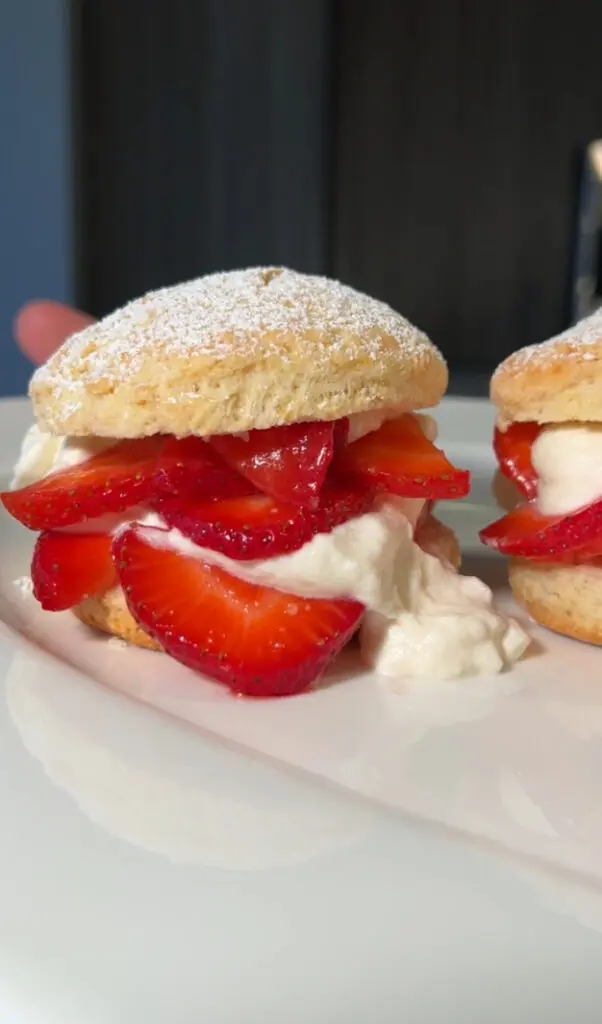 Delicious strawberry and cream-filled biscuit sandwich dusted with powdered sugar.