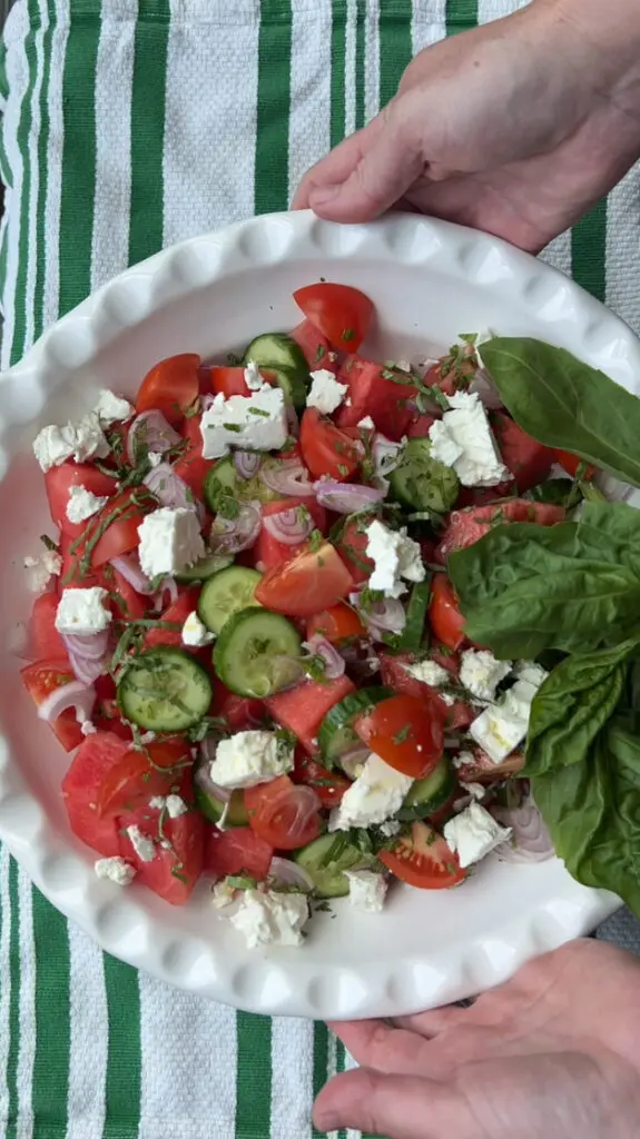 Fresh salad with tomatoes, cucumbers, feta cheese, and spinach leaves.