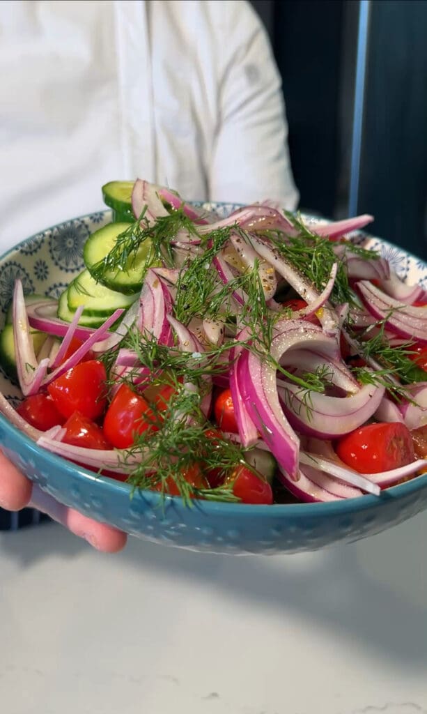 A fresh salad with cucumbers, tomatoes, and red onions.
