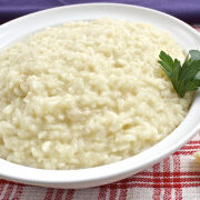 A bowl of three-cheese risotto topped with parsley.