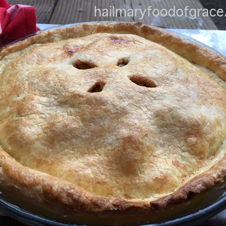 A pie is sitting on a table next to a red napkin.